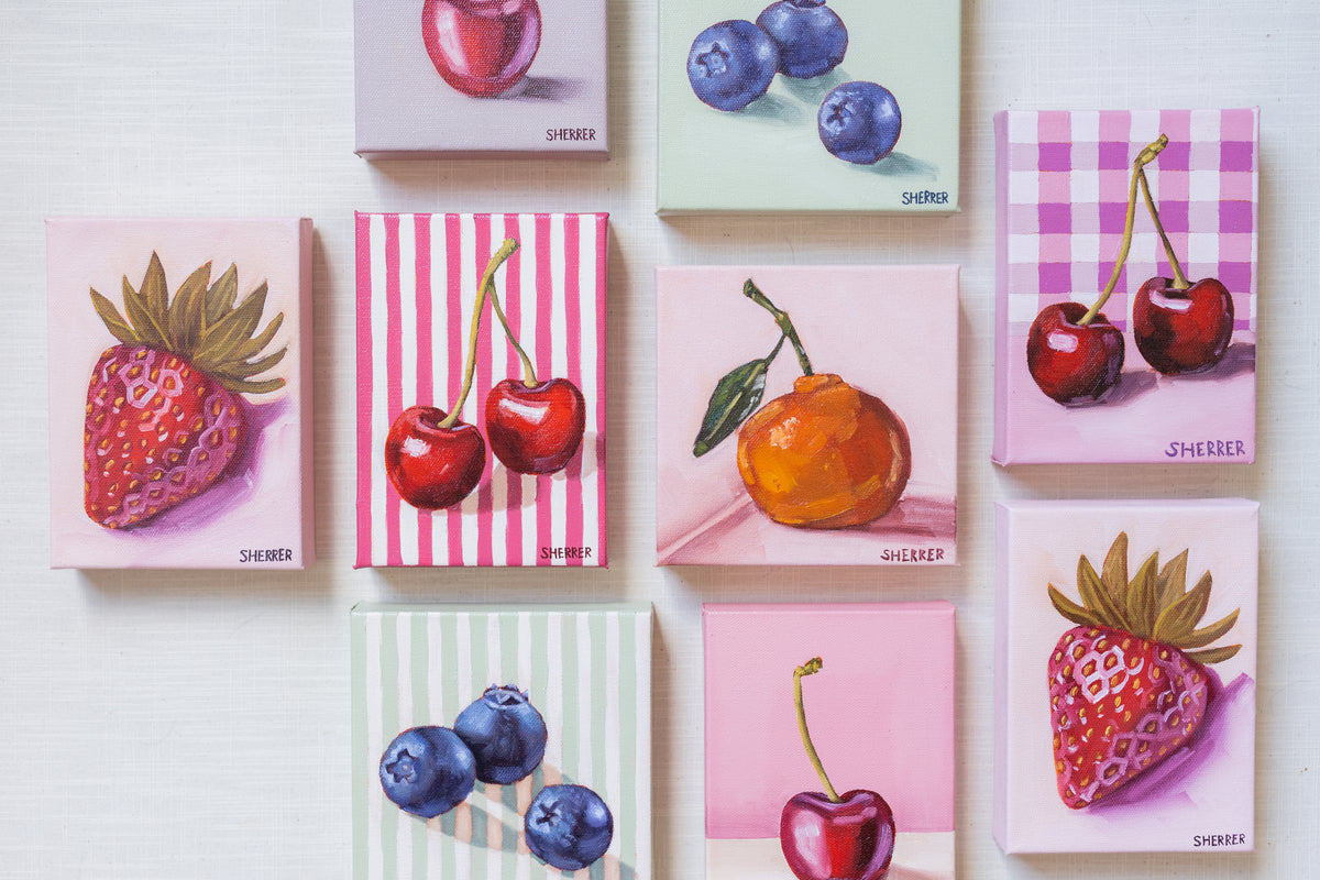 Eight small fruit paintings arranged on a pale surface.