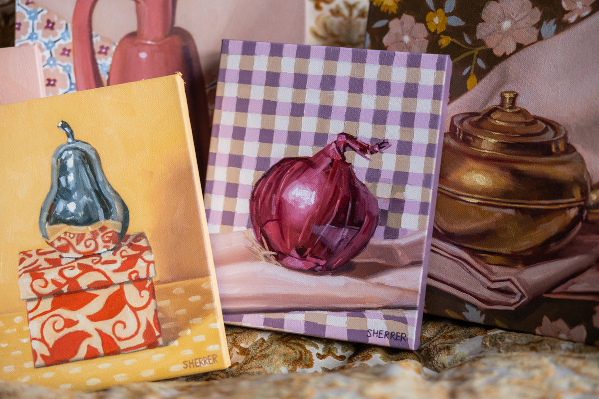Red Onion on Gingham displayed among colorful still-life paintings, with a red onion against purple-and-white checks.
