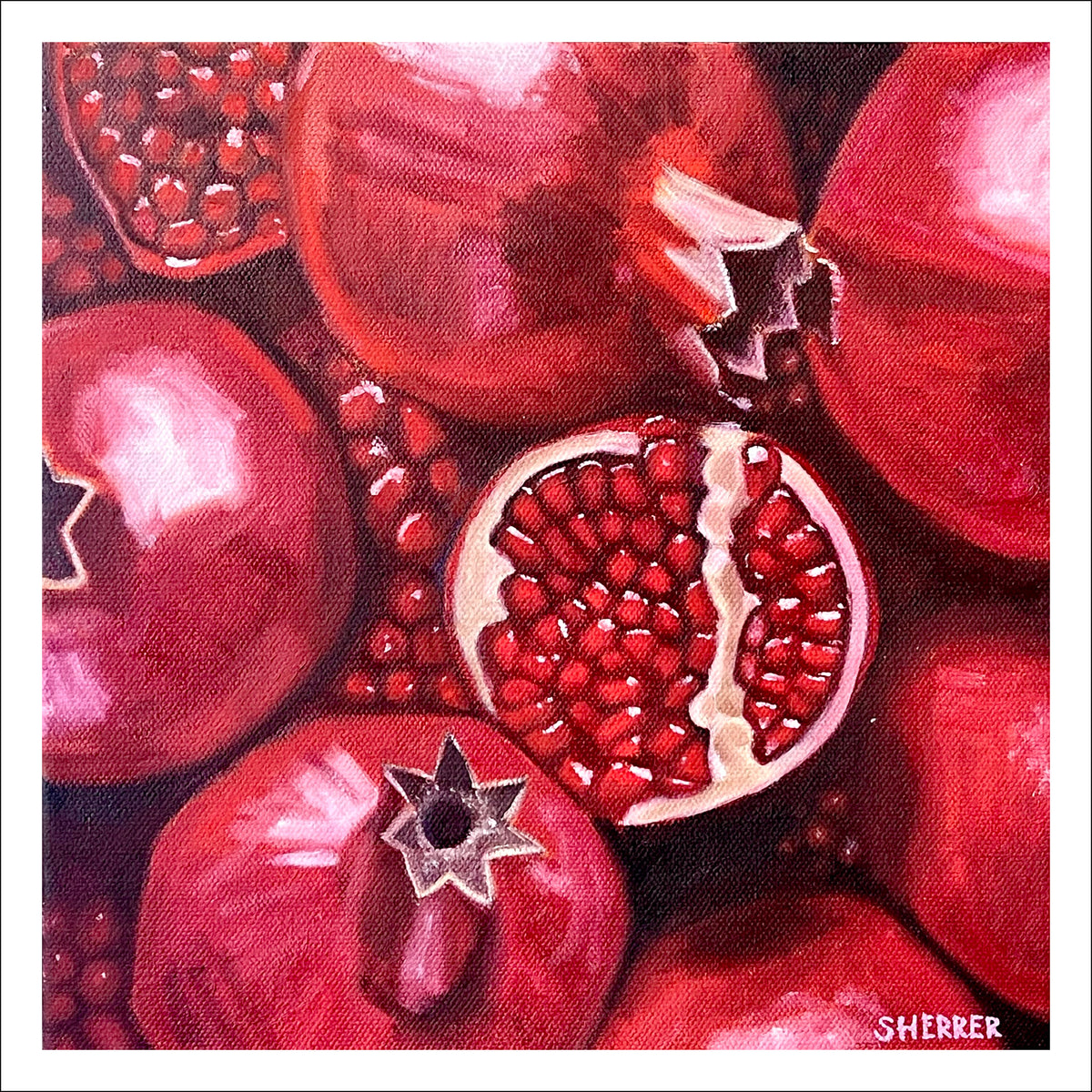 Pomegranate fine art print by Caroline Sherrer, featuring a close up of scattered whole and cut pomegranates. 