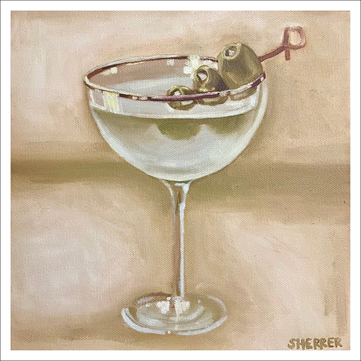 Martini fine art print by Caroline Sherrer, featuring a classic martini glass topped with three stuffed olives on a toothpick. The martini sits on a gently textured tan background.